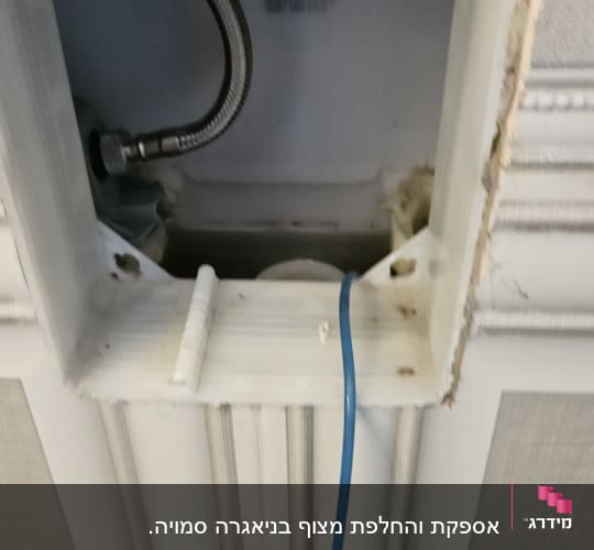 צינור מתכת גמיש וחוט כחול בקיר